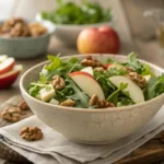 Fresh Apfel-Walnuss-Salat with vibrant apples, walnuts, and greens, beautifully arranged in a rustic kitchen setting.